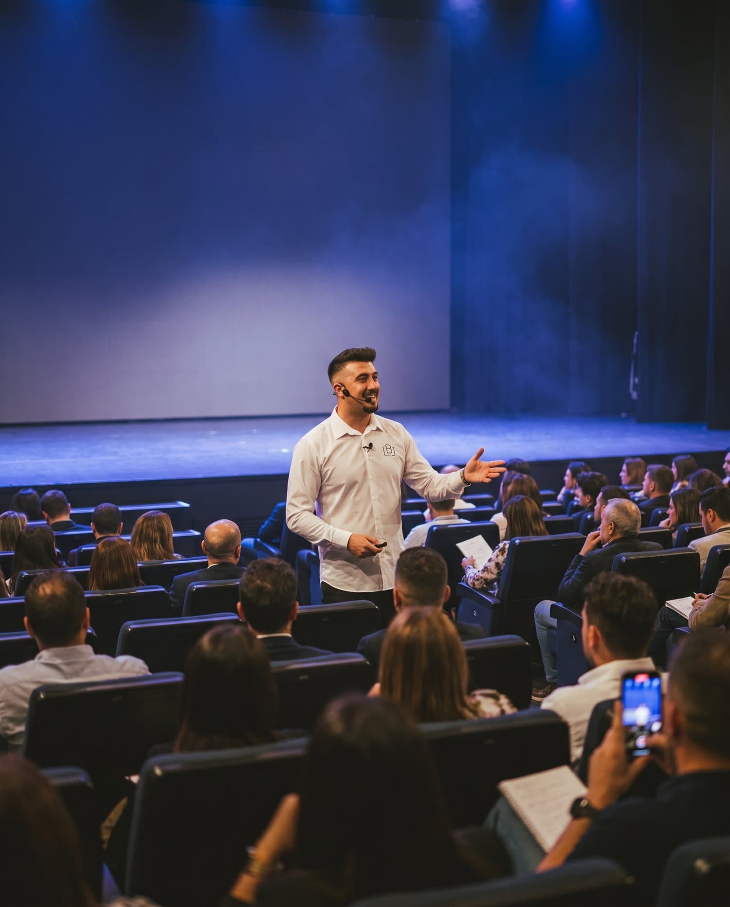 Iván Ballesteros hablando entre el público en un auditorio lleno de hosteleros